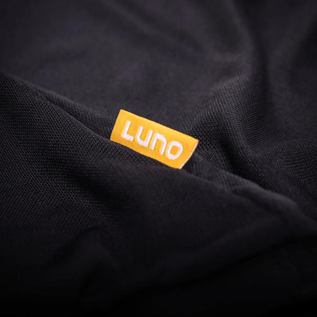 Close-up of a black fabric with an orange "LUNO HQ" tag, essential for car camping. Its texture showcases superior quality, featuring a mosquito-proof mesh design, ideal for adventures using the Pre-Owned 4Runner Trunk Window Screen.