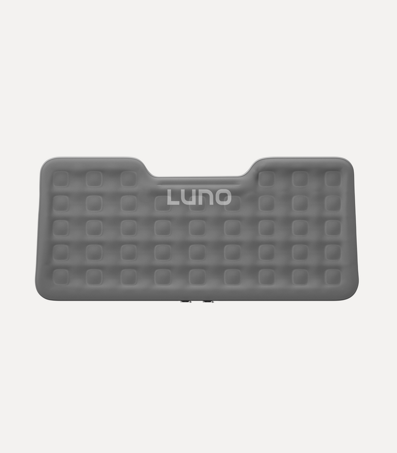 A grey rectangular inflatable mattress with a slightly curved top edge and a grid pattern. The brand name "Luno" is prominently displayed in the center. The mattress has evenly spaced square indents across the surface.