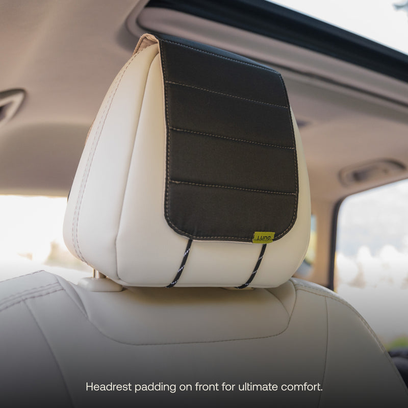 A beige car seat featuring a black padded headrest cover branded as "Luno HQ" offers enhanced comfort and practical organization. Sunlight streams through the sunroof, highlighting the easy-to-install pre-owned Headrest Organizer. Text reads, "Headrest padding on front for ultimate comfort.
