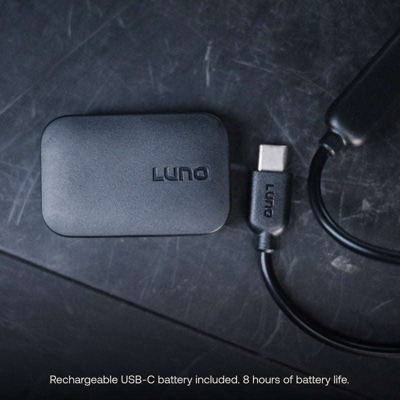 A black rectangular USB-C battery device branded "Luno®" is on a dark surface, connected via a USB-C cable. The text at the bottom reads, "Rechargeable USB-C battery pack included. 8 hours of battery life." Perfect for powering your Camping String Lights with adjustable brightness.