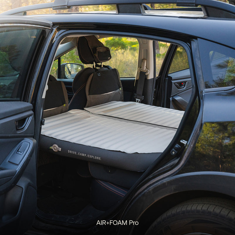 The Subaru Crosstrek Car Camping Mattress fits the backseat for your adventures. With the back door open, you see the comfy mattress sporting “Drive. Camp. Explore.”—perfect for car camping comfort on every trip.
