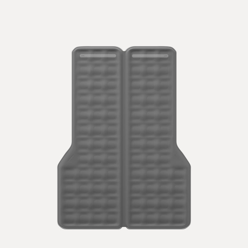 A gray, elongated, rectangular cushion with a grid pattern, featuring two small rectangular holes near the top. The cushion has two symmetrical indentations on each lower side, likely for fitting into a specific type of seating or furniture.