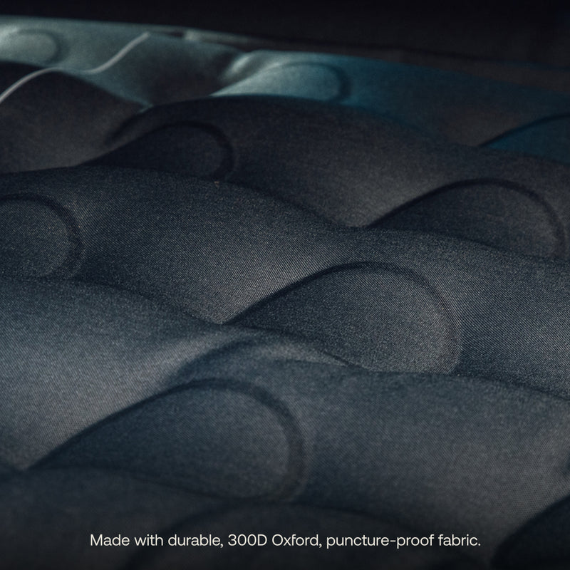 Close-up of the Luno® AIR Truck Bed Mattress’s dark, quilted surface. Text below reads: "Made with durable, 300D Oxford, puncture-proof fabric for a comfortable sleeping area.