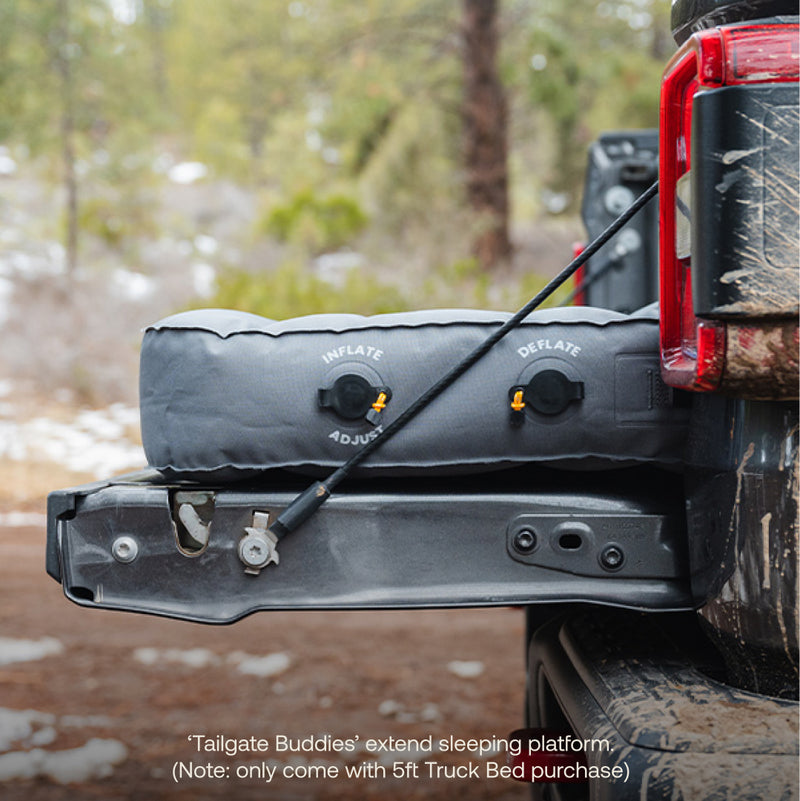 A gray Luno® Tailgate Buddies cushion attaches to a truck’s open tailgate, extending the AIR Truck Bed Mattress for extra comfort. Inflate/deflate valves are visible. Included with a 5ft Luno® AIR Truck Bed Mattress purchase.