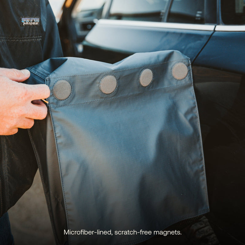 Close-up of a person attaching a sleek microfiber-lined cover using scratch-free magnets, ideal for vintage cars. Text reads, "Luno HQ’s Gear & Shoe Storage Bag (Pre-Owned): Microfiber-lined, scratch-free magnets.
