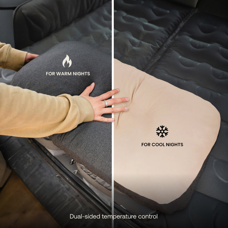 A hand flips a Luno® Car Camping AIR+FOAM Pro Starter Bundle cushion—one side says “For Warm Nights” with a flame icon, the other “For Cool Nights” with a snowflake icon. Ideal for car camping, it offers dual-sided temperature control.