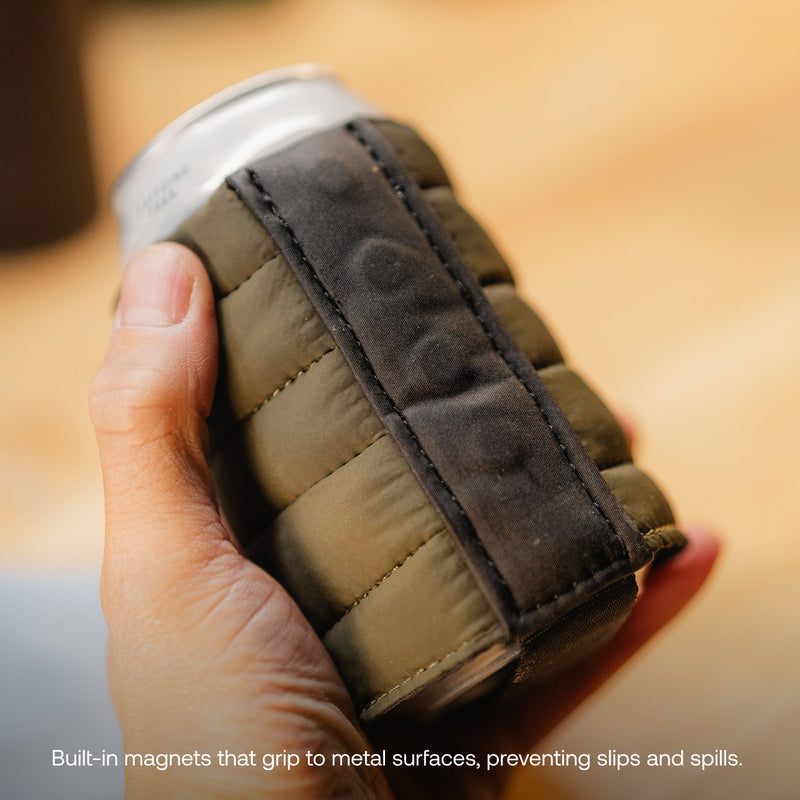 A hand holds a drink in the Magnetic Can Cooler, a padded green and black holder with a built-in magnet strip for grip and insulation. Bottom text: Built-in magnets stick to metal surfaces, preventing slips and spills.