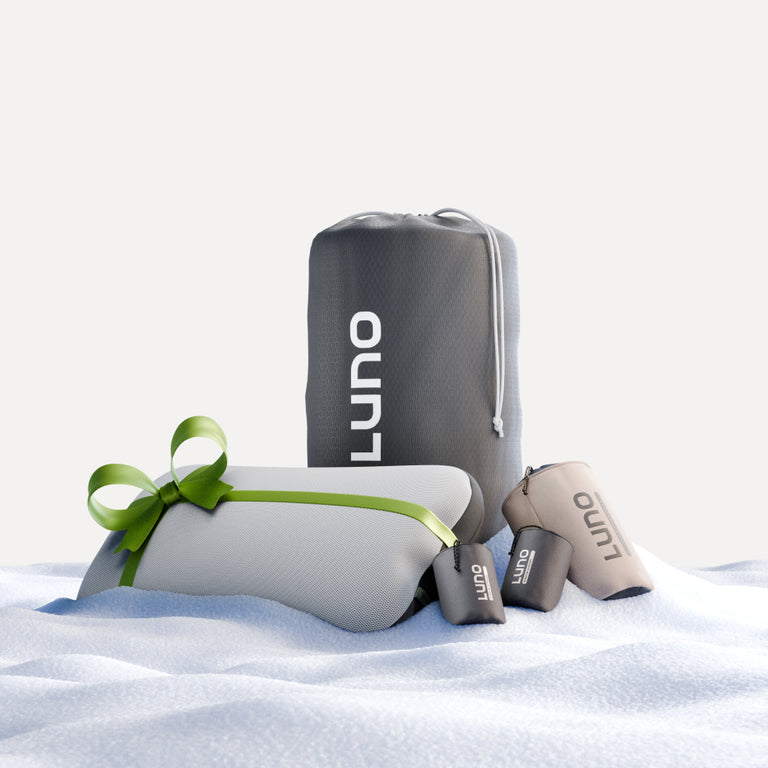 Set against a soft, snowy backdrop, the 4Runner AIR Starter Bundle by Luno® is ideal for your upcoming 4Runner adventure. The collection features a gray drawstring bag, two smaller pouches, and a rectangular gift elegantly wrapped with a green ribbon. Its design is simple and minimalistic on a white background.