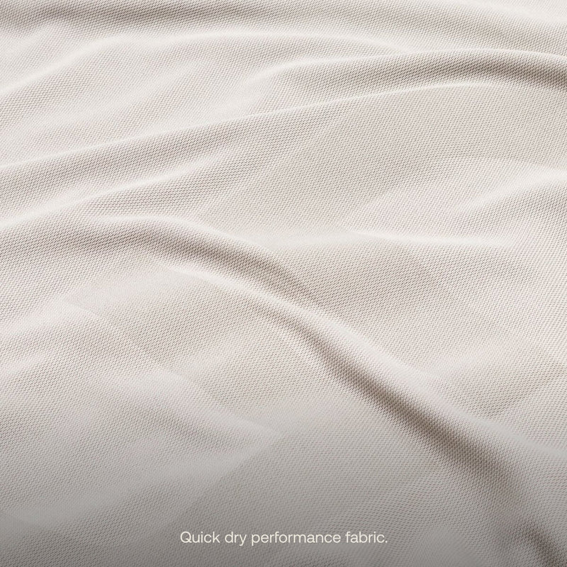 A close-up of a light-colored fabric with visible texture and slight ripples from the AIR Van Front Cab Mattress Fitted Sheet by Luno HQ, in pre-owned condition. The material features text at the bottom that reads, "Quick dry performance fabric." Enjoy fast USA shipping.
